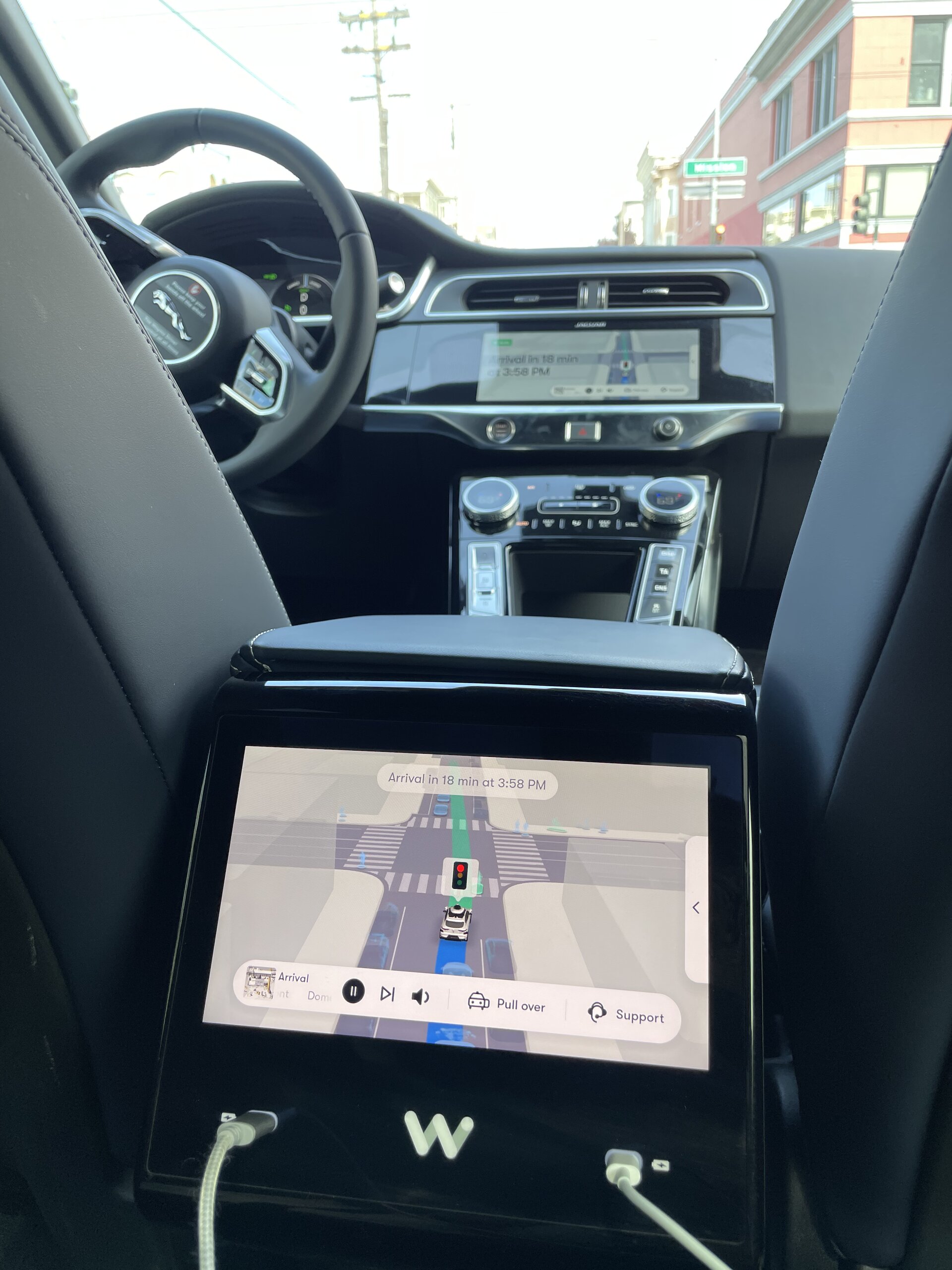 Waymo 的後座面板,畫面上可以看到車子偵測到周邊的景物,下方還有兩個手機充電插孔