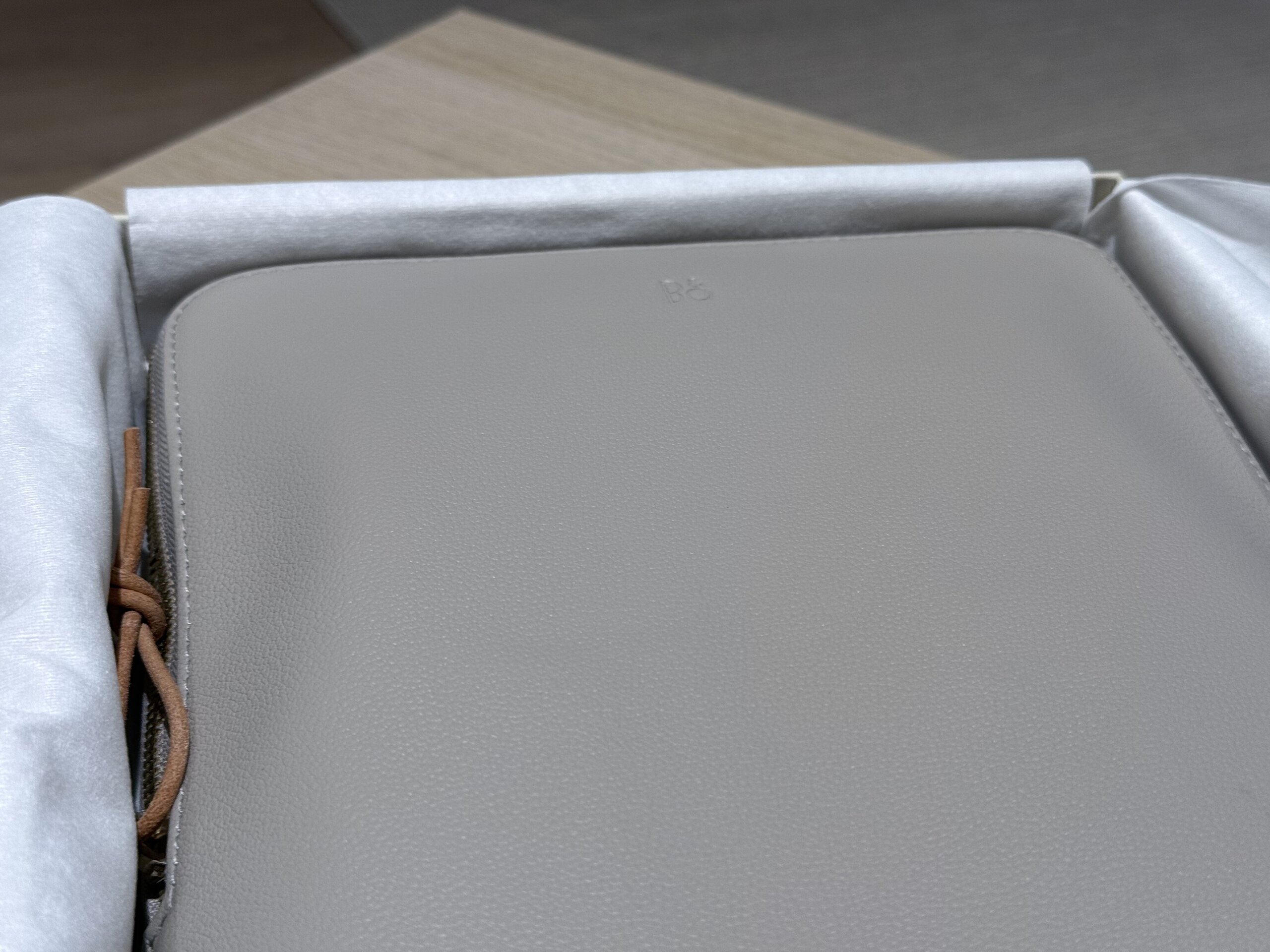Beoplay H100 包裝內部，展示一個高級皮革收納包，皮面柔軟細膩，拉繩以皮革綁繩設計，質感十足。