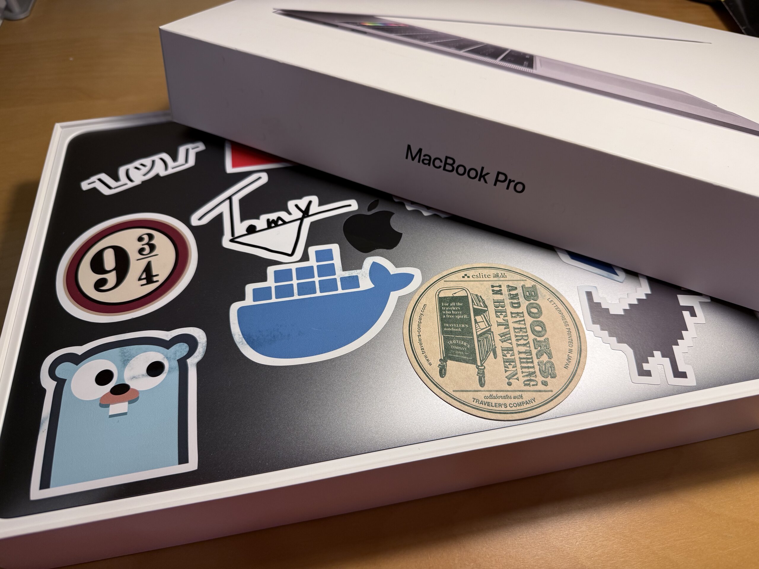 貼滿貼紙的 MacBook Pro 放在即將闔上的盒子中