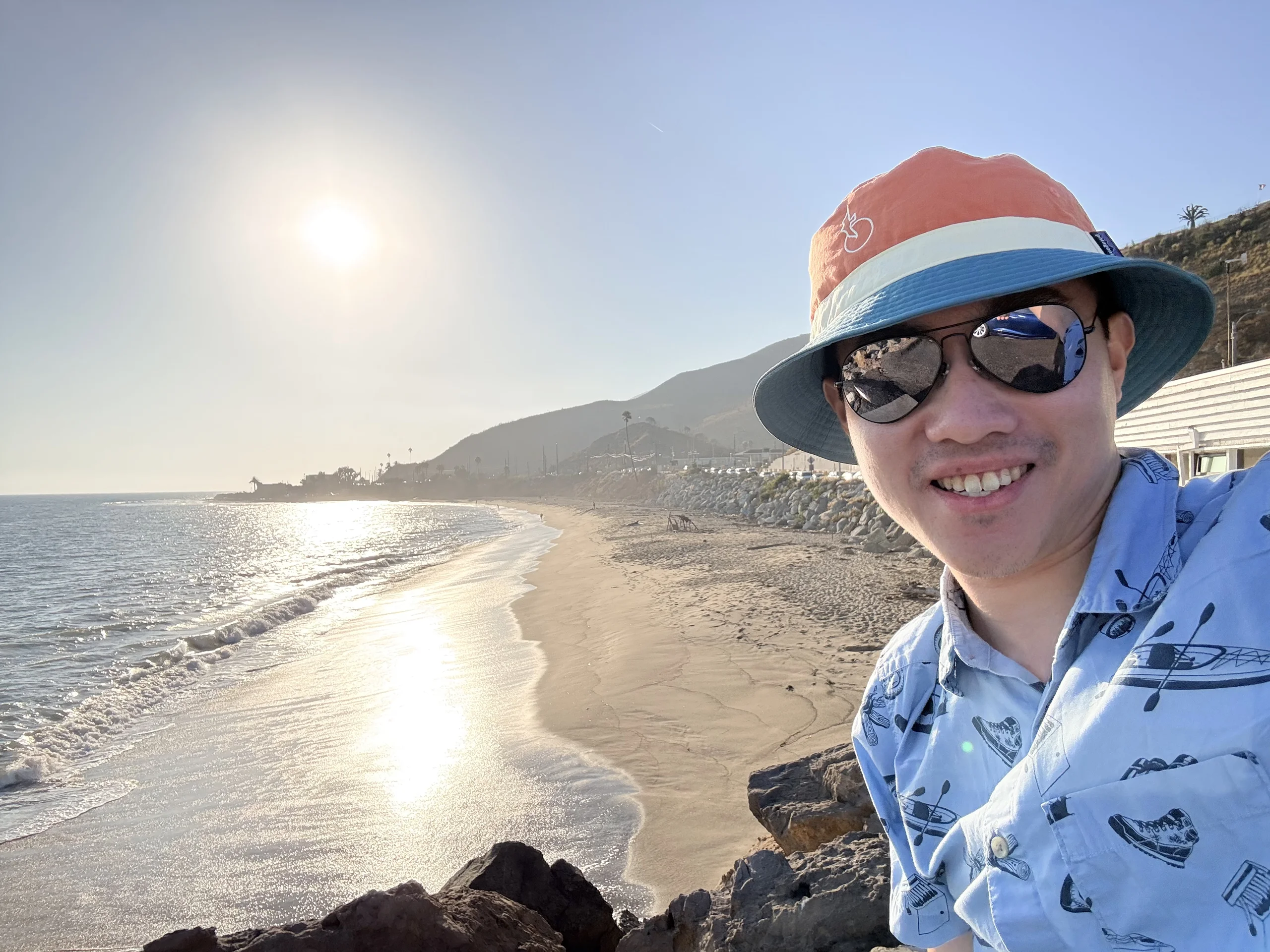 在馬利布海灘邊微笑自拍,夕陽照耀海面
