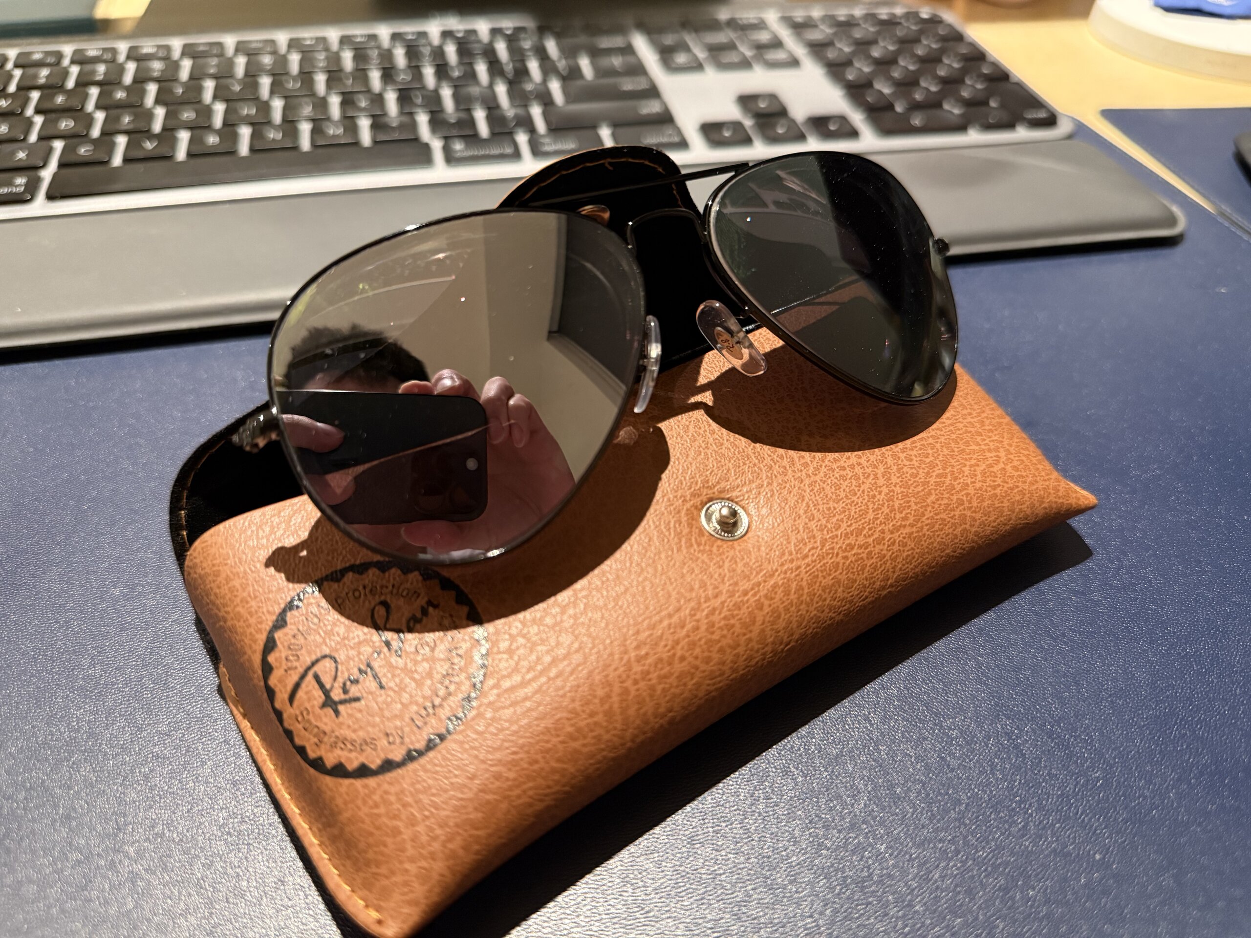 Ray-Ban 墨鏡放在棕色皮革眼鏡盒上